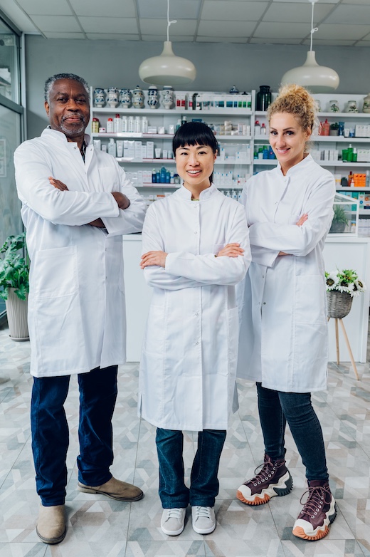 Full length of an interracial team of healthcare workers in pharmacy.
