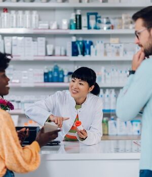 Japanese woman pharmacist selling drugs to a customer in a pharmacy